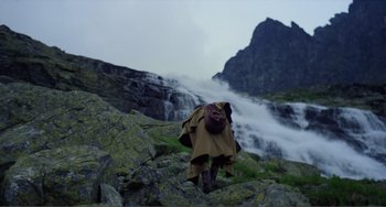 Movie still from “Nosferatu the Vampyre” (1979), directed by Werner Herzog – A person in a raincoat walking up a mountain; Extreme Wide shot, High angle