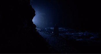 Movie still from “Nosferatu the Vampyre” (1979), directed by Werner Herzog – A person standing in a cave at night; Extreme Wide shot, High angle