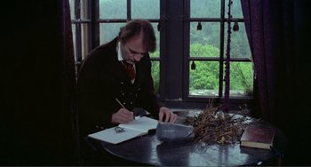 Movie still from “Nosferatu the Vampyre” (1979), directed by Werner Herzog – A man sitting at a table writing in a notebook; Medium shot, High angle