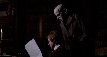 Movie still from “Nosferatu the Vampyre” (1979), directed by Werner Herzog – A man and a woman looking at a sheet of paper in a library; Medium shot, Over the shoulder angle