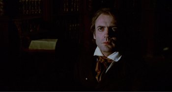 Movie still from “Nosferatu the Vampyre” (1979), directed by Werner Herzog – A man wearing a suit and tie in a dark room; Close Up shot, Low angle