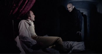 Movie still from “Nosferatu the Vampyre” (1979), directed by Werner Herzog – Two men sitting on a bed talking to each other; Medium shot, Over the shoulder angle