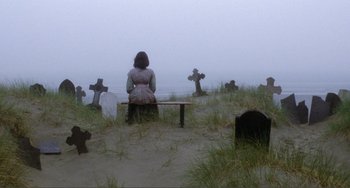 Movie still from “Nosferatu the Vampyre” (1979), directed by Werner Herzog – A woman sitting on a bench in a graveyard; Wide shot, High angle