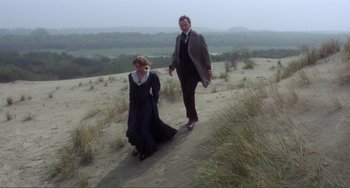 Movie still from “Nosferatu the Vampyre” (1979), directed by Werner Herzog – A man and a woman are walking through the sand; Wide shot, High angle