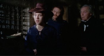 Movie still from “Nosferatu the Vampyre” (1979), directed by Werner Herzog – A man and a woman standing next to each other in a dark room; Medium shot, Over the shoulder angle