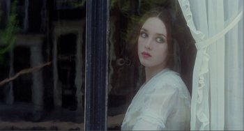 Movie still from “Nosferatu the Vampyre” (1979), directed by Werner Herzog – A woman in a white shirt looking out a window; Close Up shot, Over the shoulder angle