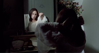 Movie still from “Nosferatu the Vampyre” (1979), directed by Werner Herzog – A woman in front of a mirror brushing her hair; Medium shot, Over the shoulder angle