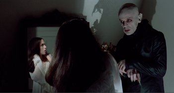 Movie still from “Nosferatu the Vampyre” (1979), directed by Werner Herzog – A group of people standing in front of a mirror; Medium shot, Over the shoulder angle