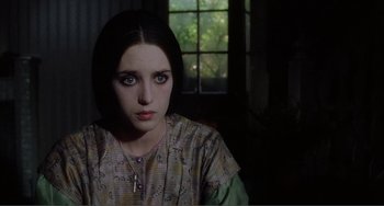 Movie still from “Nosferatu the Vampyre” (1979), directed by Werner Herzog – A young woman with a cross necklace stares into the camera; Close Up shot, Over the shoulder angle