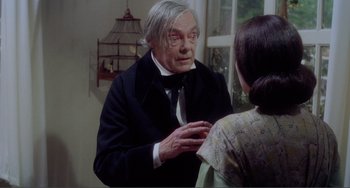 Movie still from “Nosferatu the Vampyre” (1979), directed by Werner Herzog – An older man wearing a suit and tie talking to an older woman; Medium shot, Over the shoulder angle