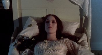 Movie still from “Nosferatu the Vampyre” (1979), directed by Werner Herzog – A woman laying in a bed wearing a white dress; Close Up shot, High angle