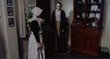 Movie still from “Nosferatu the Vampyre” (1979), directed by Werner Herzog – A woman and a man dressed in costume in a living room; Wide shot, High angle