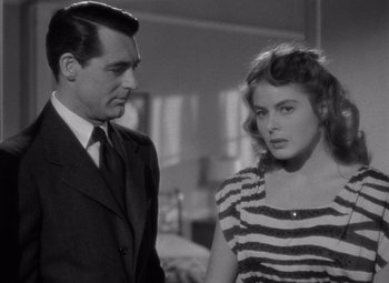 Movie still from “Notorious” (1946), directed by Alfred Hitchcock – A man and a woman standing next to each other in a room; Medium shot, Over the shoulder angle