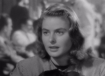 Movie still from “Notorious” (1946), directed by Alfred Hitchcock – A black - and - white photo of a woman with a bow in her hair; Close Up shot, Over the shoulder angle