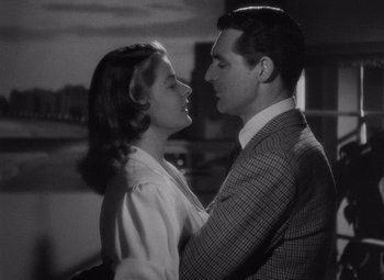 Movie still from “Notorious” (1946), directed by Alfred Hitchcock – A man and a woman embracing each other in front of a window; Close Up shot, Low angle