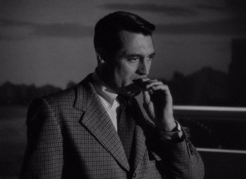 Movie still from “Notorious” (1946), directed by Alfred Hitchcock – A black and white photo of a man smoking a cigarette; Close Up shot, Over the shoulder angle