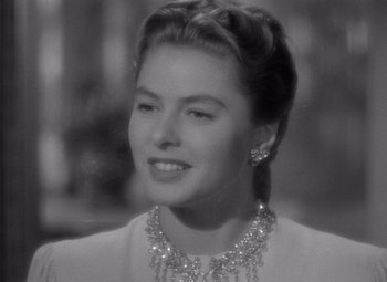 Movie still from “Notorious” (1946), directed by Alfred Hitchcock – A black - and - white photo of a woman in a white dress; Close Up shot, Over the shoulder angle