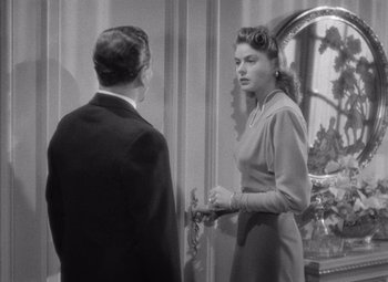 Movie still from “Notorious” (1946), directed by Alfred Hitchcock – A man and a woman standing next to each other in front of a mirror; Medium shot, Over the shoulder angle