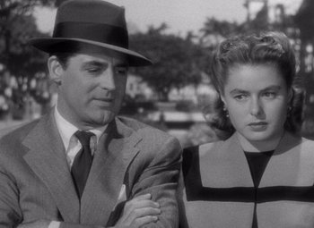 Movie still from “Notorious” (1946), directed by Alfred Hitchcock – A man and a woman standing next to each other in front of trees; Medium shot, Over the shoulder angle