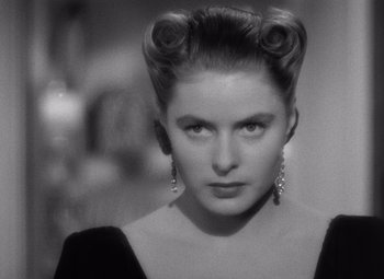 Movie still from “Notorious” (1946), directed by Alfred Hitchcock – A black and white photo of a woman with hair in a bun; Close Up shot, Over the shoulder angle