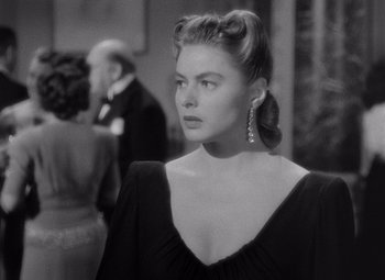 Movie still from “Notorious” (1946), directed by Alfred Hitchcock – A black and white photo of a woman in a black dress; Close Up shot, Over the shoulder angle