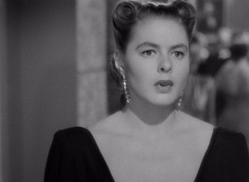 Movie still from “Notorious” (1946), directed by Alfred Hitchcock – A black and white photo of a woman in a black dress; Close Up shot, Over the shoulder angle