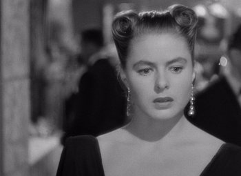 Movie still from “Notorious” (1946), directed by Alfred Hitchcock – A black and white photo of a woman with two buns; Close Up shot, Over the shoulder angle