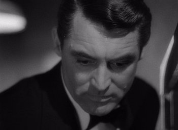 Movie still from “Notorious” (1946), directed by Alfred Hitchcock – A man in a suit and tie; Close Up shot, Over the shoulder angle