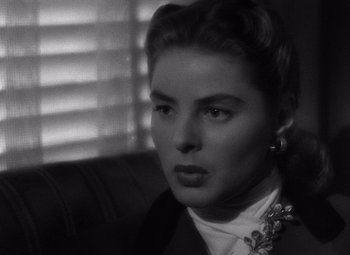 Movie still from “Notorious” (1946), directed by Alfred Hitchcock – A black - and - white photo of a woman in a suit; Close Up shot, Over the shoulder angle