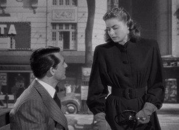 Movie still from “Notorious” (1946), directed by Alfred Hitchcock – A man and a woman standing next to each other in front of a building; Medium shot, Over the shoulder angle