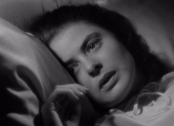 Movie still from “Notorious” (1946), directed by Alfred Hitchcock – A black and white photo of a woman laying in bed; Close Up shot, High angle