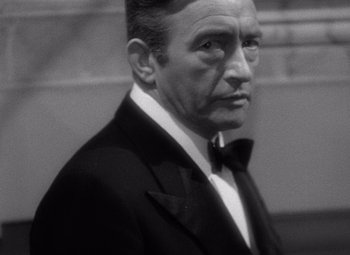 Movie still from “Notorious” (1946), directed by Alfred Hitchcock – An older man wearing a tuxedo and a bow tie; Close Up shot, High angle