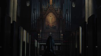 Movie still from “Novitiate” (2017), directed by Maggie Betts – A person in a black robe sitting in front of an organ; Extreme Wide shot, Low angle