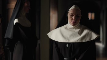 Movie still from “Novitiate” (2017), directed by Maggie Betts – A woman in a nun's outfit looking at the camera; Medium shot, Low angle