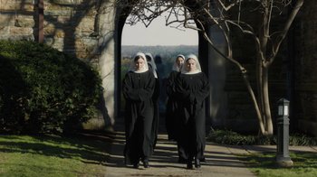Movie still from “Novitiate” (2017), directed by Maggie Betts – Two women dressed as nuns standing in front of an archway; Wide shot, High angle