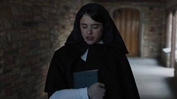 Movie still from “Novitiate” (2017), directed by Maggie Betts – A woman dressed as a nun holding a book; Close Up shot, Low angle