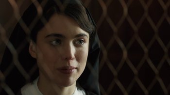 Movie still from “Novitiate” (2017), directed by Maggie Betts – A young woman with a black headscarf is looking at the camera; Close Up shot, Over the shoulder angle