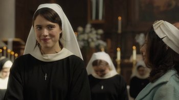 Movie still from “Novitiate” (2017), directed by Maggie Betts – A woman in a nun's outfit standing in front of candles; Close Up shot, Over the shoulder angle