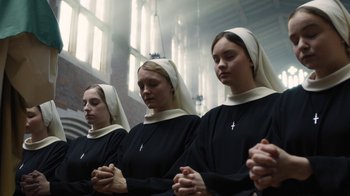 Movie still from “Novitiate” (2017), directed by Maggie Betts – A group of nuns praying in front of a window; Medium shot, High angle