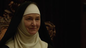 Movie still from “Novitiate” (2017), directed by Maggie Betts – An older woman wearing a nun's habit and smiling; Close Up shot, Low angle