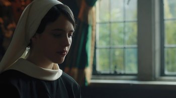 Movie still from “Novitiate” (2017), directed by Maggie Betts – A woman wearing a nun's outfit looking down at the ground; Close Up shot, Over the shoulder angle