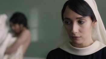 Movie still from “Novitiate” (2017), directed by Maggie Betts – A woman wearing a black and white dress with a white collar; Close Up shot, Over the shoulder angle