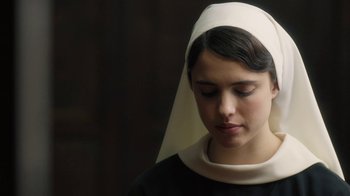 Movie still from “Novitiate” (2017), directed by Maggie Betts – A woman wearing a nun's hat and a black shirt; Close Up shot, Over the shoulder angle