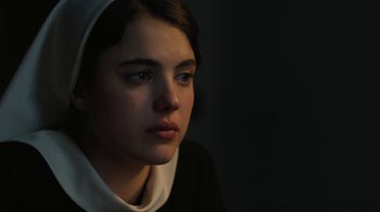 Movie still from “Novitiate” (2017), directed by Maggie Betts – A young woman wearing a nun's habit looking into the distance; Close Up shot, Over the shoulder angle