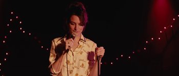 Movie still from “Obvious Child” (2014), directed by Gillian Robespierre – A woman holding a microphone while standing on a stage; Close Up shot, Over the shoulder angle