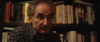 Movie still from “Obvious Child” (2014), directed by Gillian Robespierre – An older man wearing glasses in front of a book shelf; Close Up shot, Over the shoulder angle