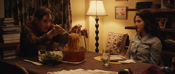 Movie still from “Obvious Child” (2014), directed by Gillian Robespierre – A person is eating noodles at a dinner table; Medium shot, Over the shoulder angle