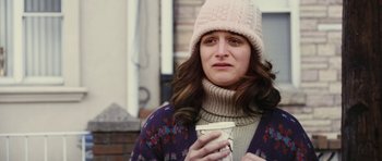 Movie still from “Obvious Child” (2014), directed by Gillian Robespierre – A woman wearing a hat and holding a cup of coffee; Close Up shot, Over the shoulder angle