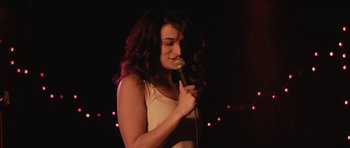 Movie still from “Obvious Child” (2014), directed by Gillian Robespierre – A woman holding a microphone in her hand; Close Up shot, Over the shoulder angle