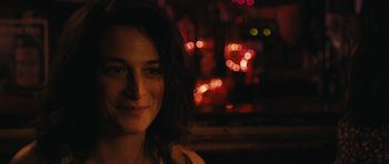 Movie still from “Obvious Child” (2014), directed by Gillian Robespierre – A woman's face in front of blurry lights at night; Close Up shot, Over the shoulder angle
